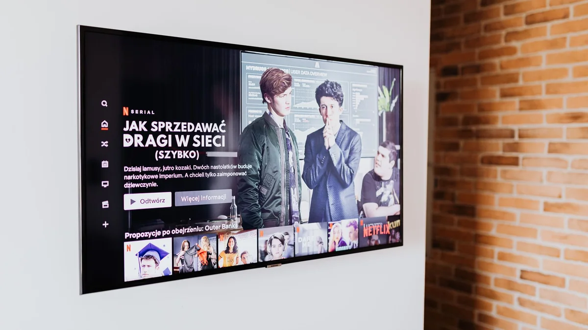 Smart TV displaying streaming content in modern living room setting with exposed brick wall, illustrating iptv files