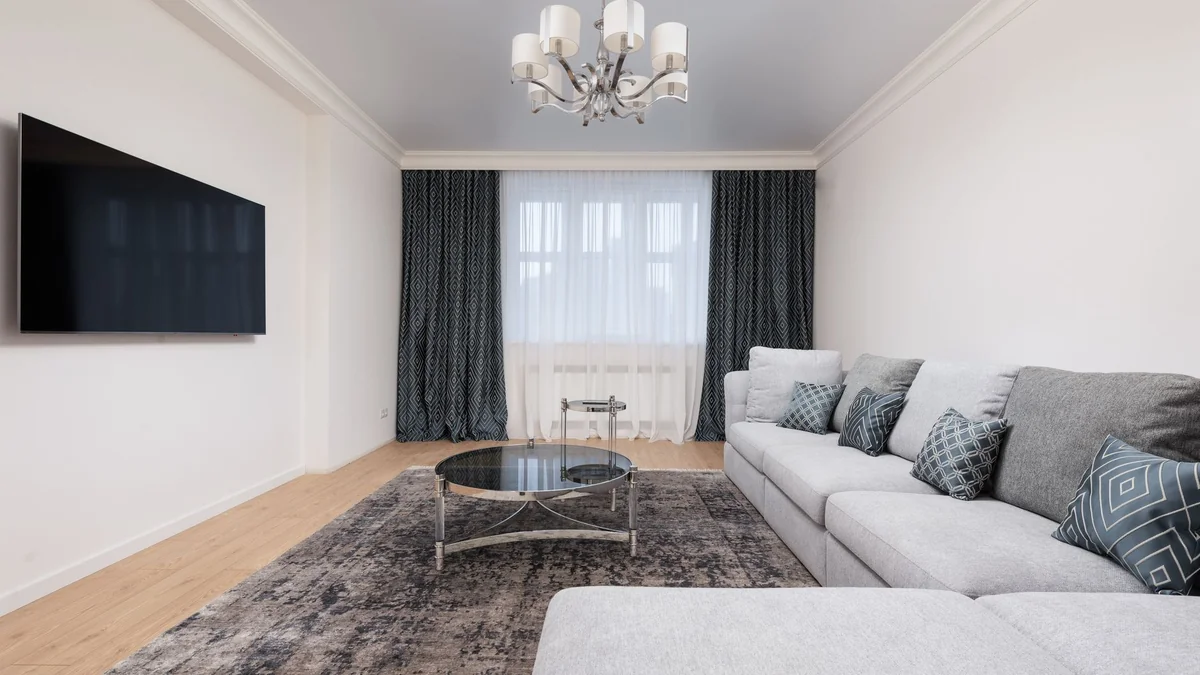 Contemporary living room with decorative cushions on sofa against table, illustrating iptv smarters pro mac