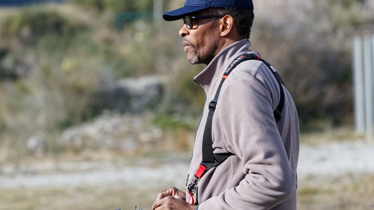 A man outdoors using a remote control in a sunny environment, wearing casual attire, illustrating tivimate buffering